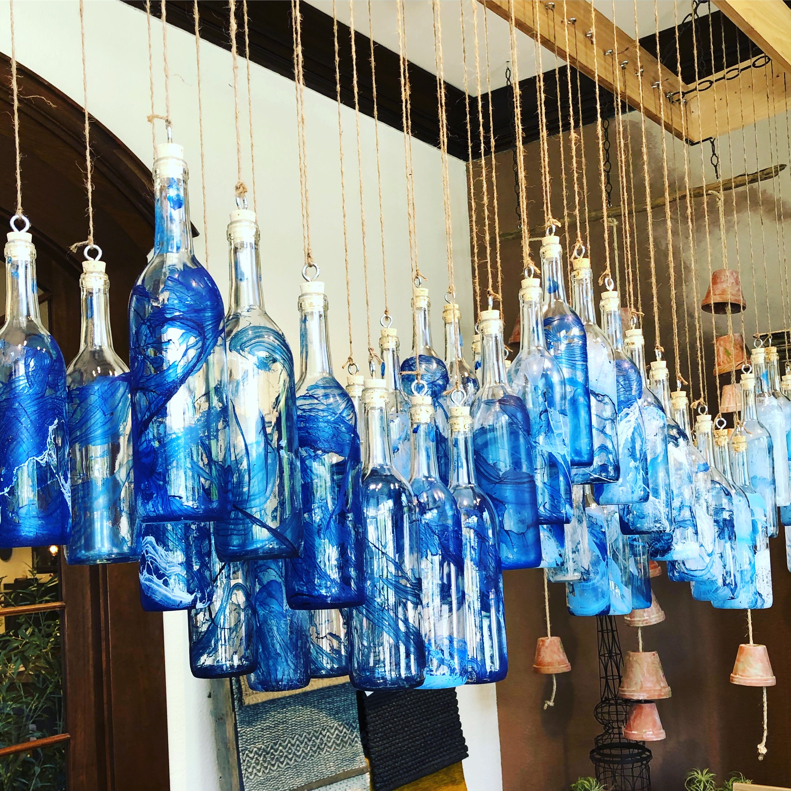 Chandelier made of blue glass bottles hanging indoors.