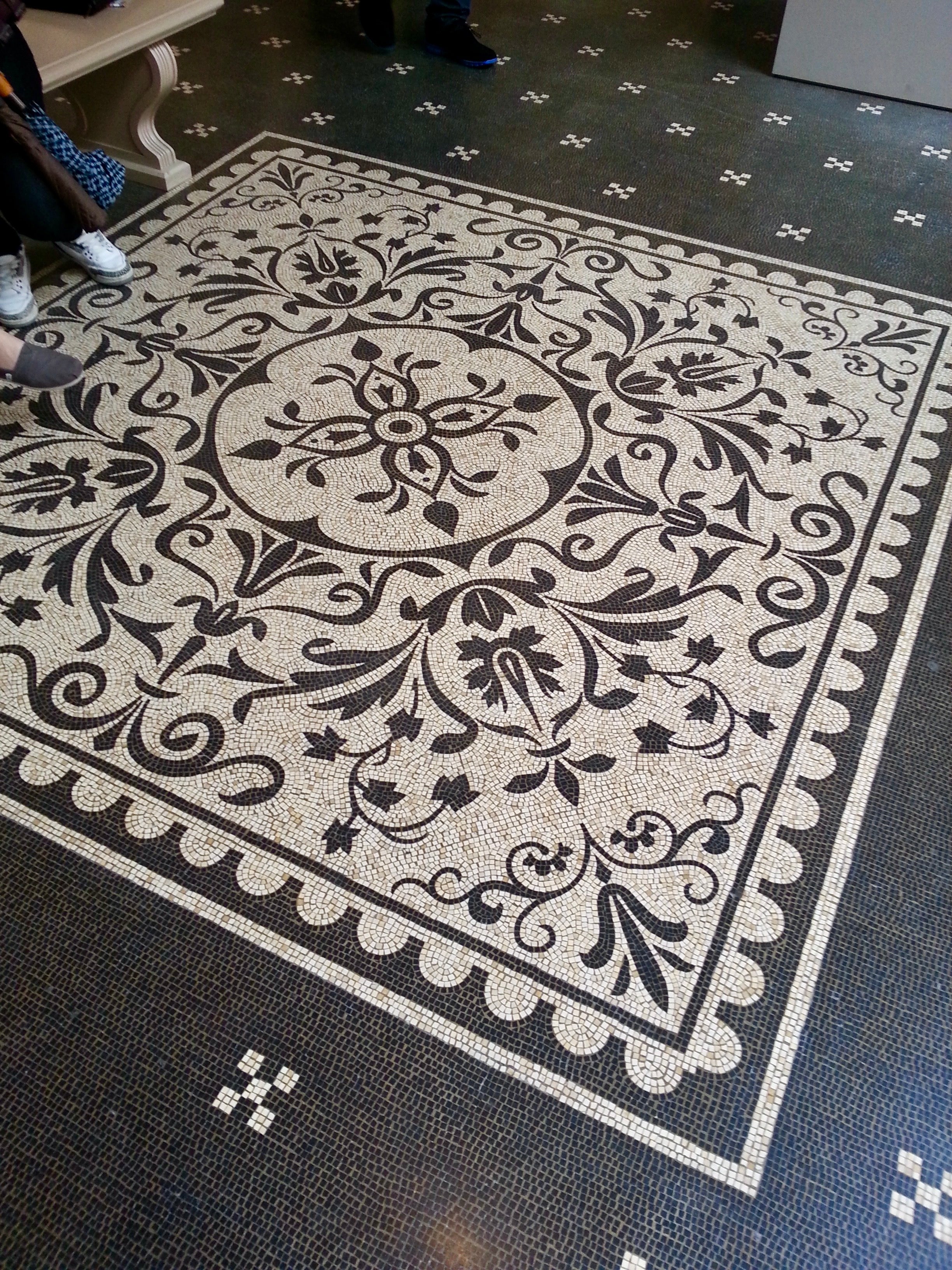 Decorative black and white patterned rug on a dark floor.