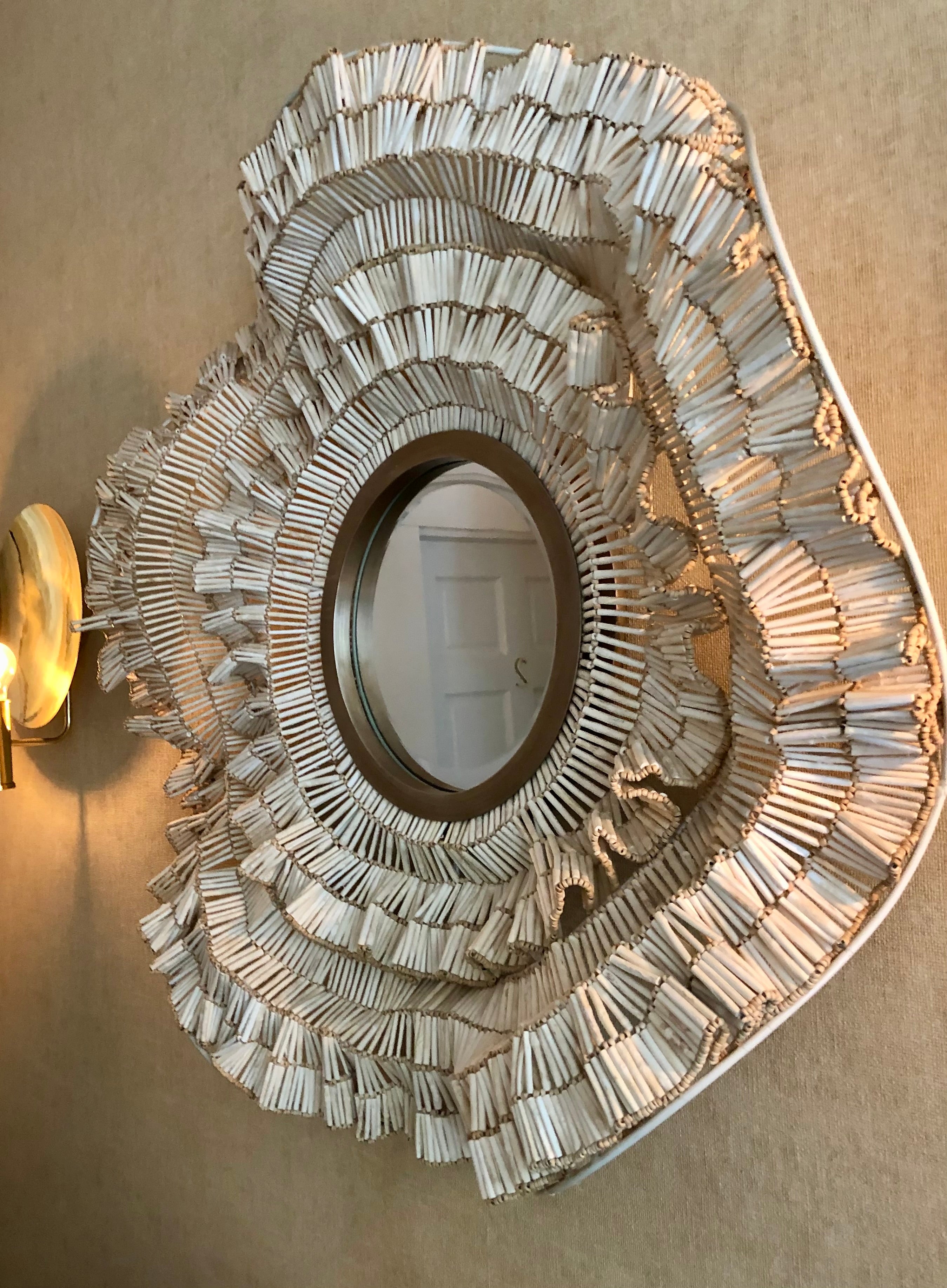 Decorative wall mirror with intricate design on a beige wall