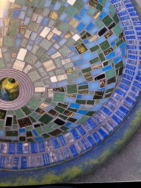 Mosaic pattern with blue and green tiles on a circular design