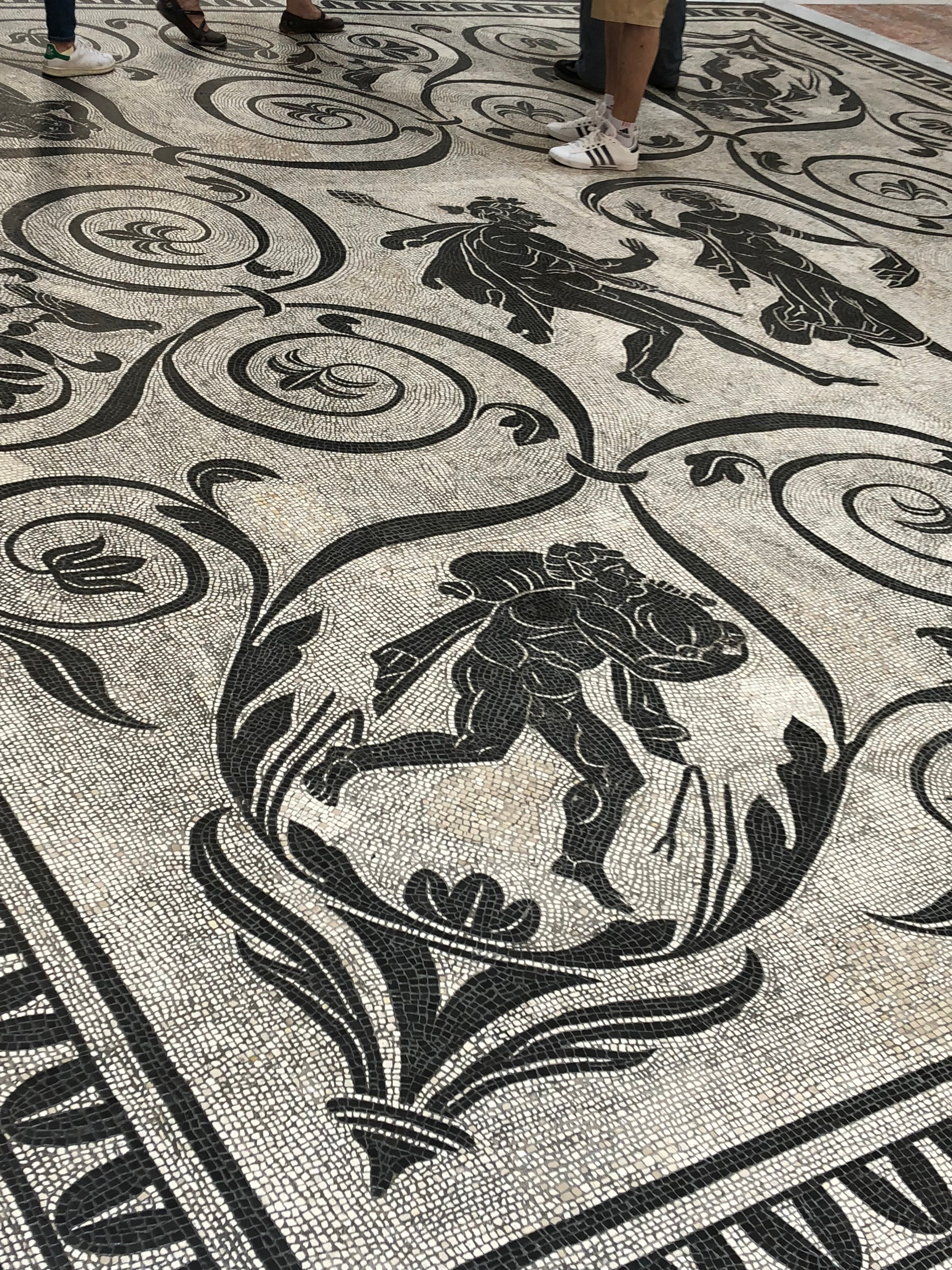 Close-up of a decorative floor with intricate black patterns on a light background
