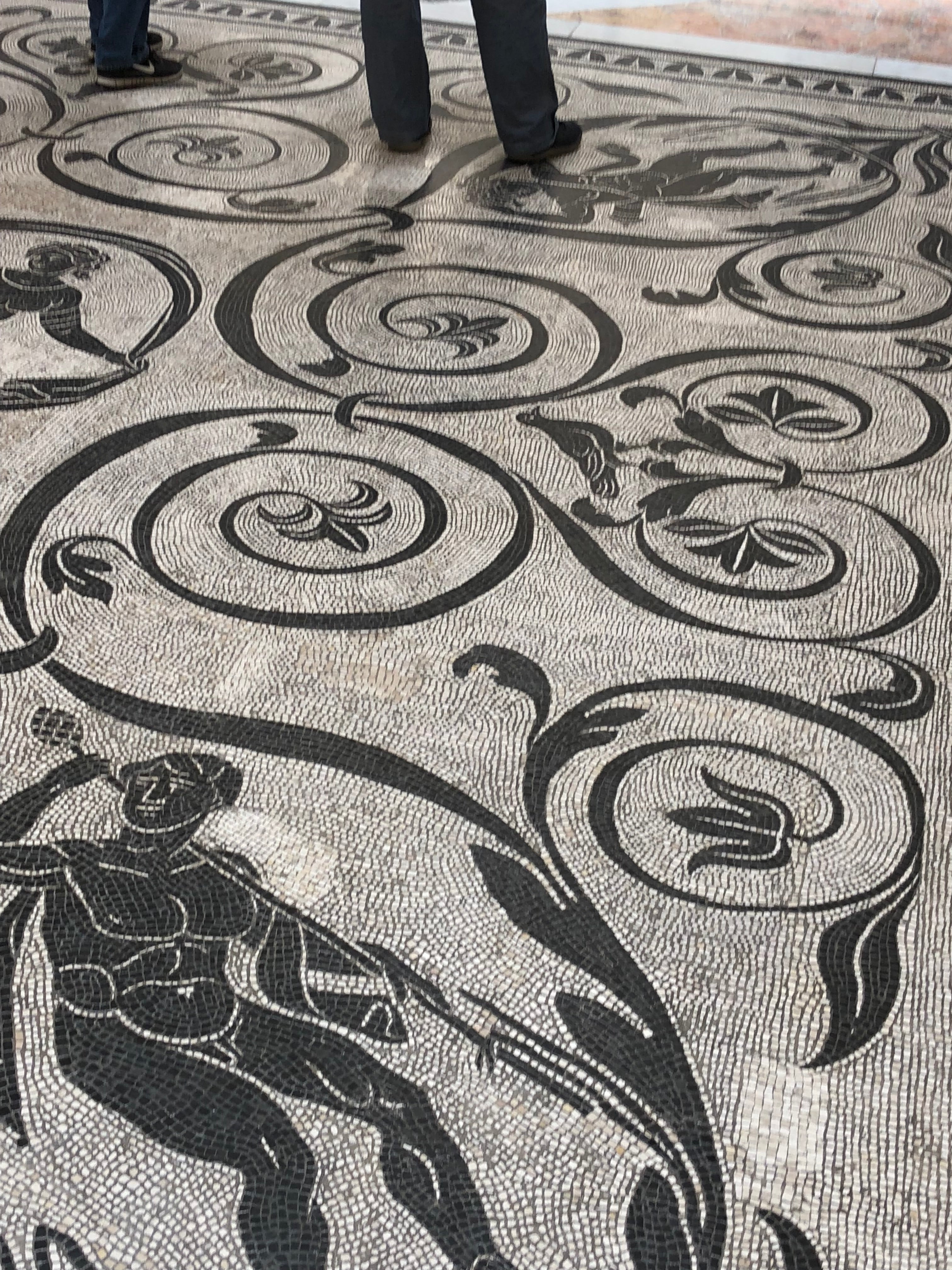 Close-up of a woven fabric with black floral patterns on a neutral background