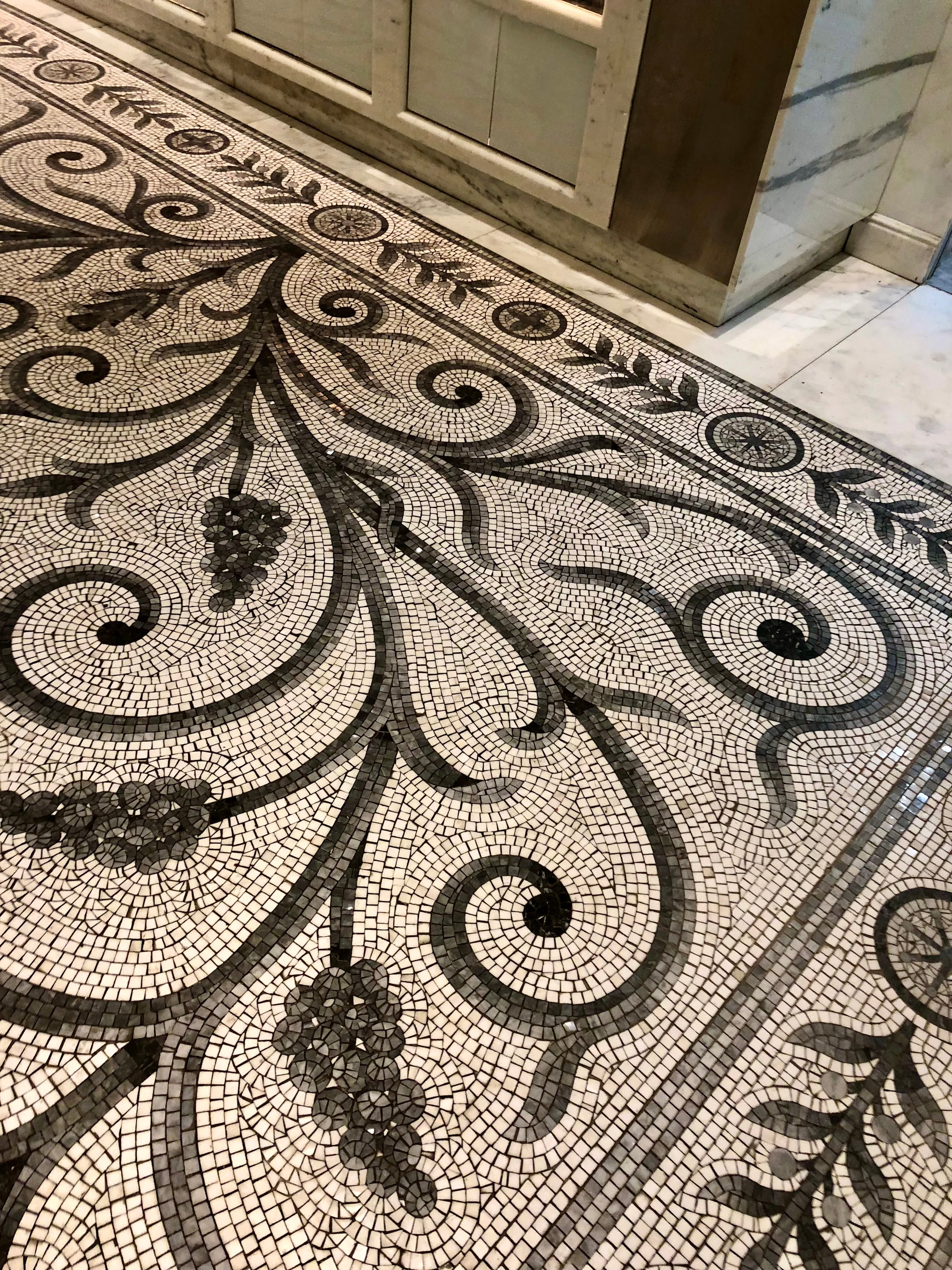 Decorative mosaic floor with intricate patterns and black and white color scheme.