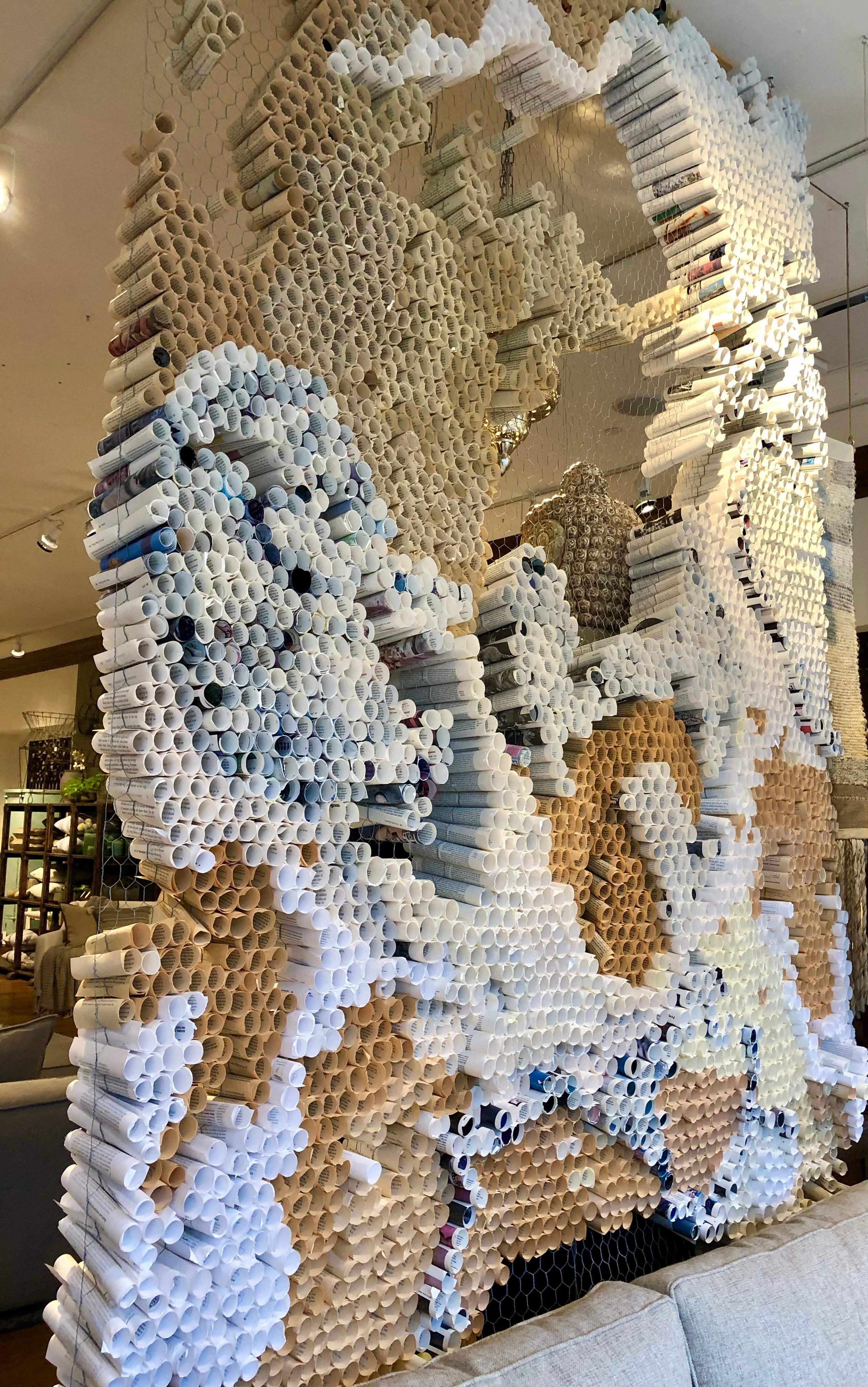 Large decorative letter 'M' made from interlocking bricks in a modern indoor setting.