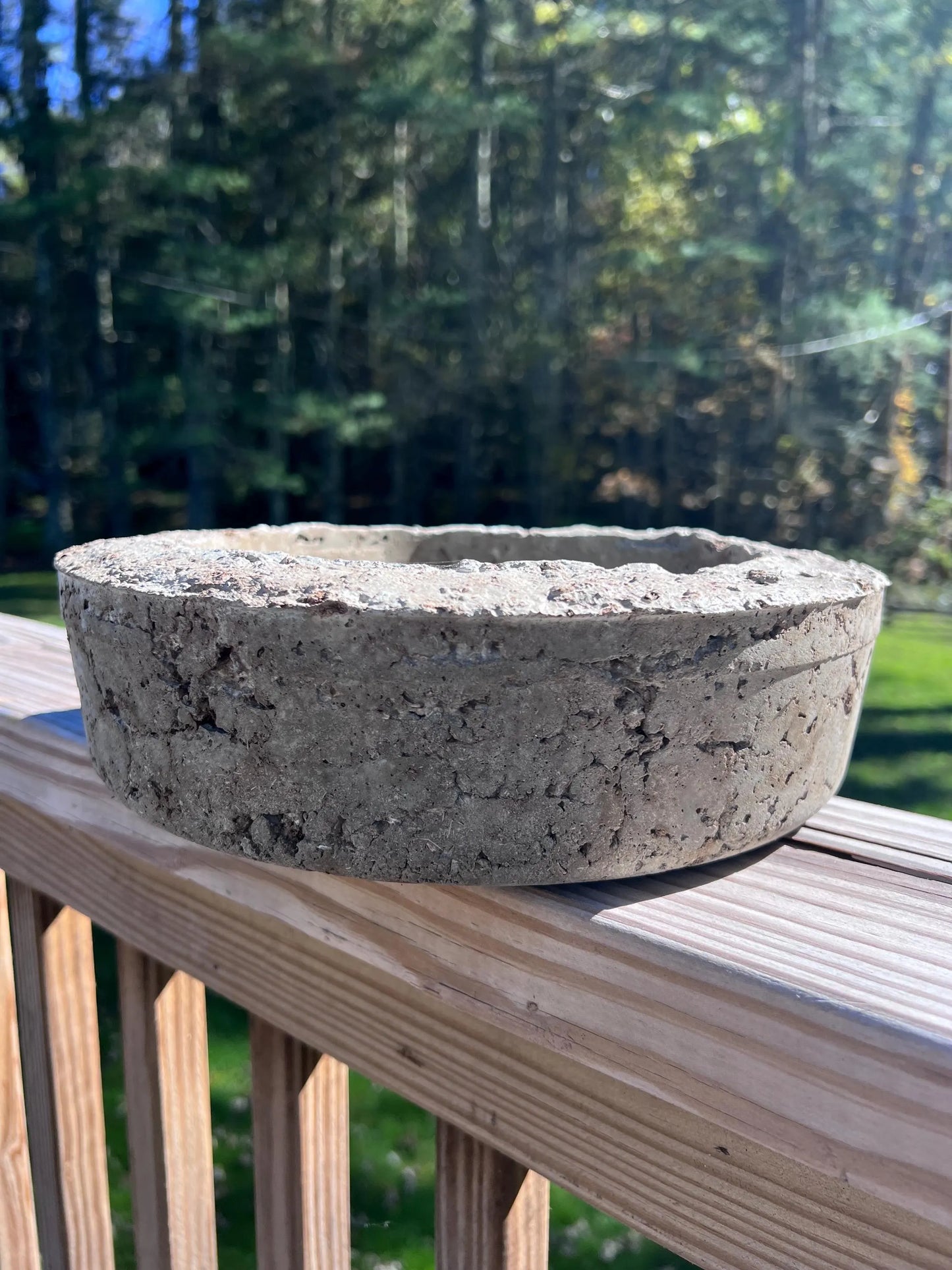 Concrete bowl on a wooden deck with a blurred natural background