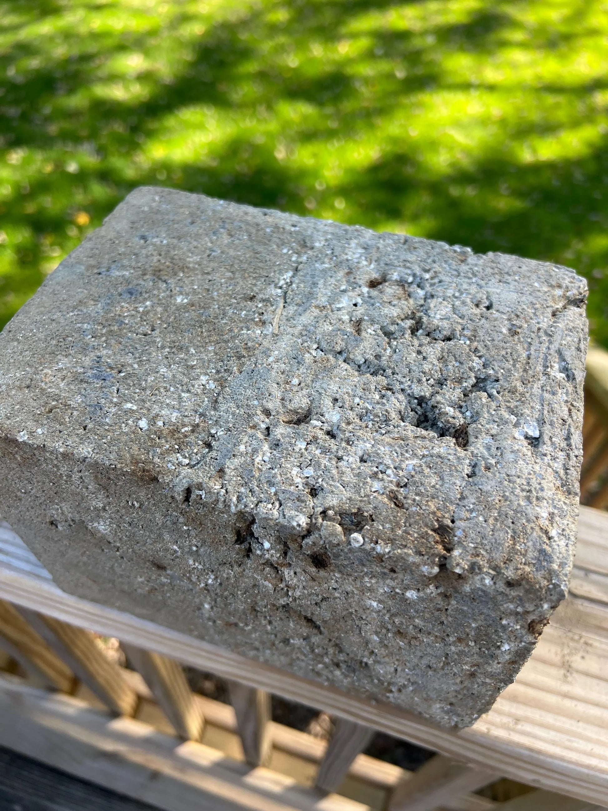 Concrete block with a textured surface on a blurred green background