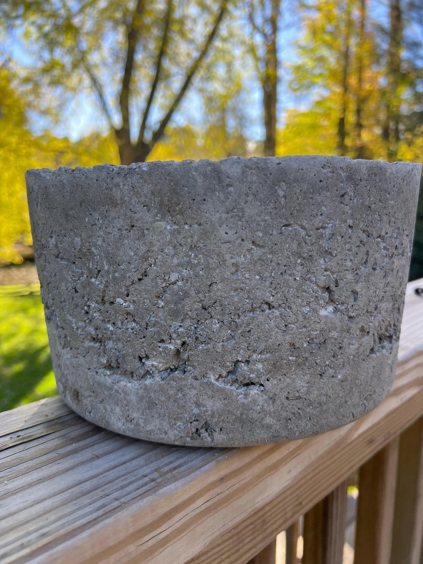 Concrete block on a wooden surface with a blurred natural background