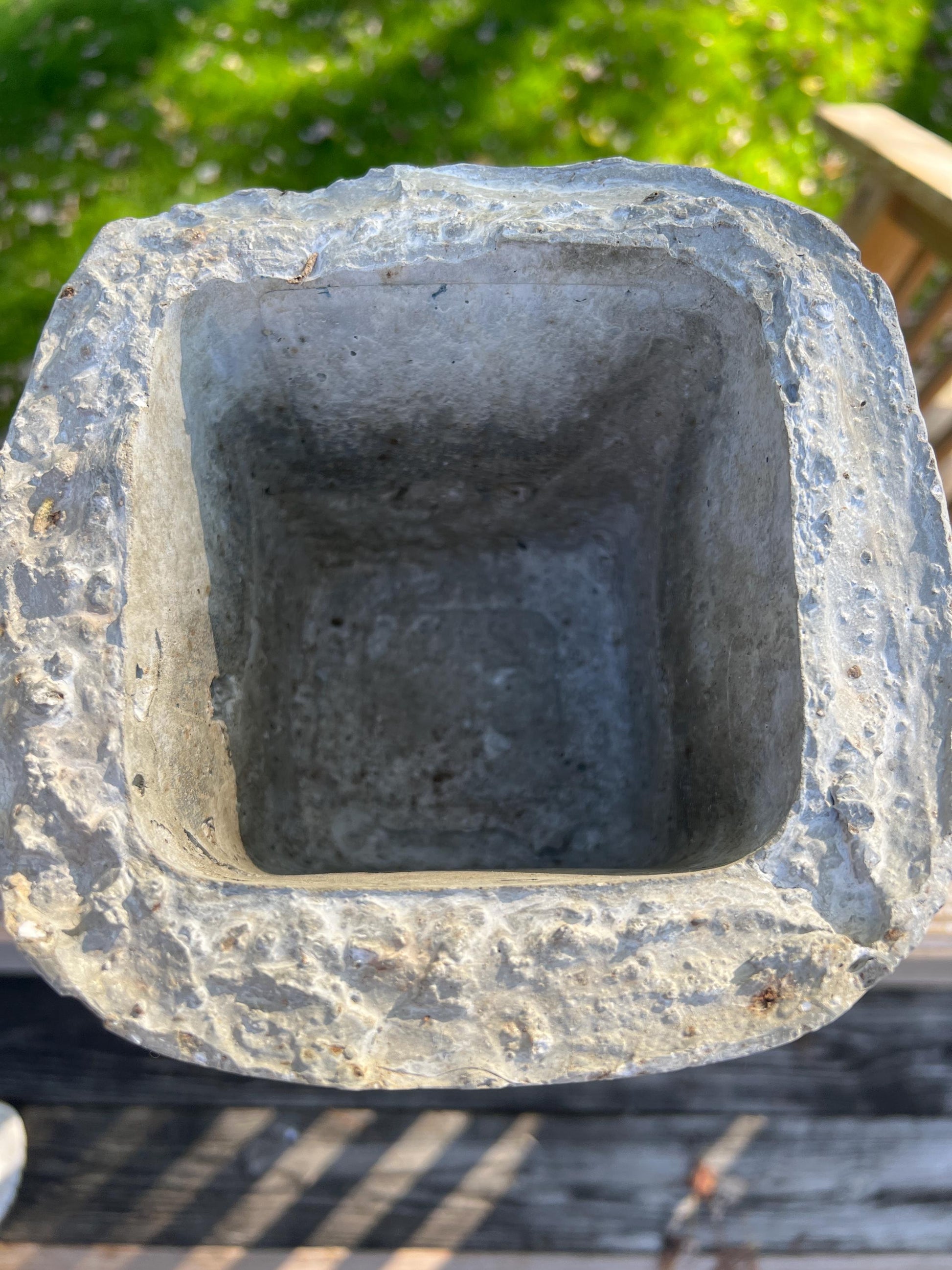 Stone planter with a textured surface on a blurred natural background