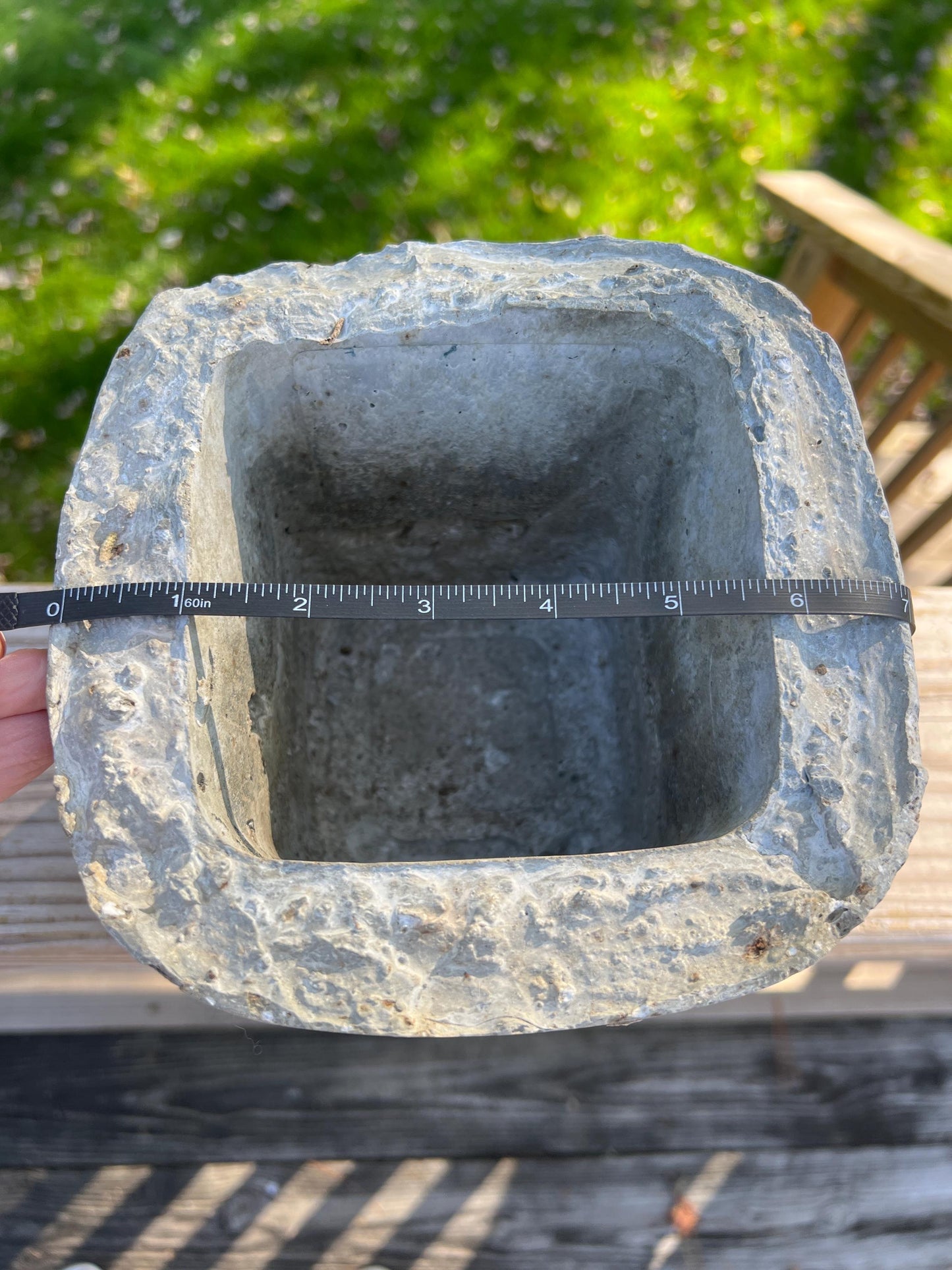 Cement block with a ruler for scale against a green grass background